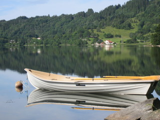 Reflection of boat houses and trees in crystal clear lake water...Norway