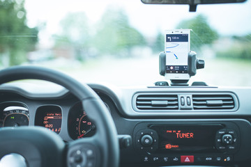 Obraz premium Auto Cockpit von innen, Interieur, Hände am Lenkrad, Smartphone in Handyhalterung, Navigation 