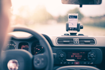 Auto Cockpit von innen, Interieur, Hände am Lenkrad, Smartphone in Handyhalterung, Navigation 
