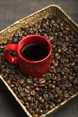 Cup of coffee on roasted coffee beans