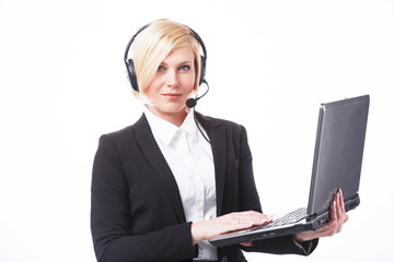 Call center operator, blonde woman dressed in black jacket holding laptop before white background...