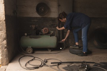 Female worker using portable spray paint machine