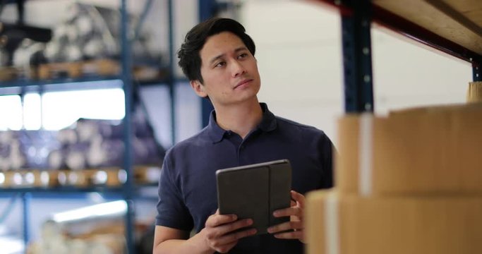 Male working in distribution warehouse with digital tablet