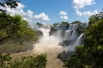 Waterfalls at Iguazu falls framed by trees and blue sky