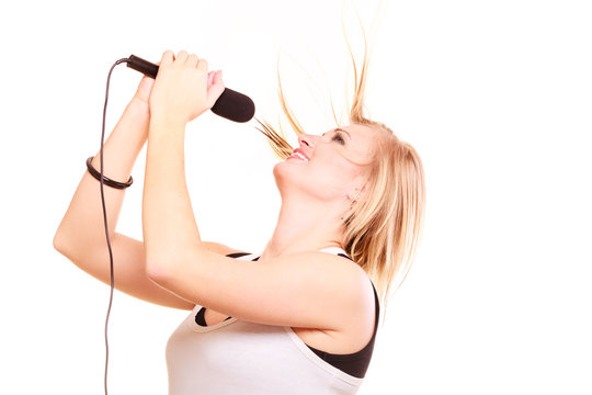 Blonde woman singing to microphone, profile view