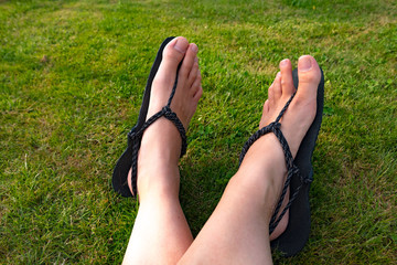 Feet of a young woman wearing selfmade huarache sandals, minimalist shoes