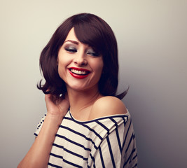 Beautiful happy young woman with short hair land red lips ooking down. Vintage toned portrait