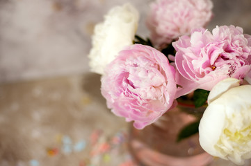 Fresh pink peonies flowers on aged wooden background. Selective focus. Toned image.