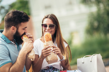 Young couple is eating sandwiches and having a great time