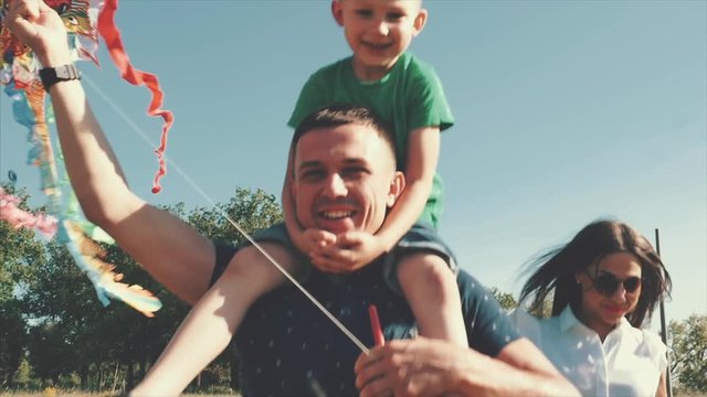 Happy family, mom, dad and son are walking in nature, launching an air snake. Stock footage.