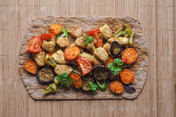 Vegetables with grilled meat on a bamboo napkin. Asian food.