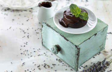Hot chocolate soufflés with chocolate cream sauce on the shabby chic background