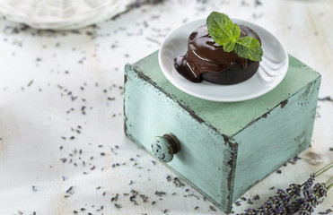 Hot chocolate soufflés with chocolate cream sauce on the shabby chic background