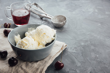 Vanilla ice cream in a grey bowl. Homemade organic dessert with jam, sweet cherry and strawberry