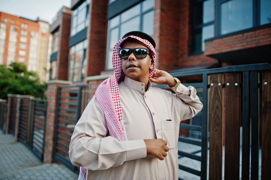 Middle Eastern arab business man posed on street against modern building with sunglasses.