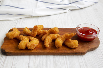 Fried shrimps tempura with sauce on wooden board over white wooden background, side view. Close-up.