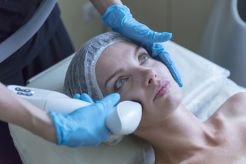 Beautiful woman in professional beauty salon during photo rejuvenation procedure