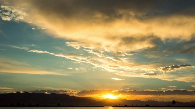 Time lapse of colorful summer sunset as the sun dips behind the mountains over Utah Lake.