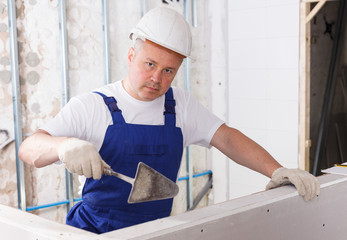 Plasterer taping drywall joints
