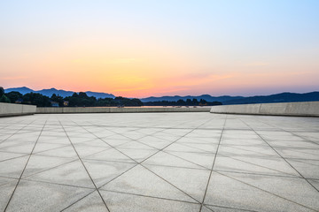 Empty square floor and hill silhouette at dusk