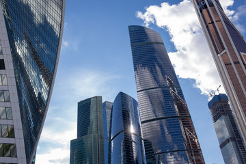 Fototapeta na wymiar Moscow, Russia - 07 09 2018: Bottom view of Moscow-City skyscrapers with futuristic design with reflection of clouds