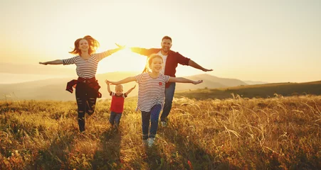 Fotobehang Gelukkig gezin: moeder, vader, kinderen, zoon en dochter bij zonsondergang © JenkoAtaman