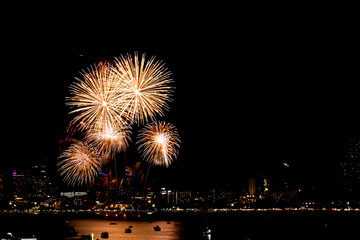 Fototapeta premium Many flashing fireworks with night cityscape background celebrate New Year.