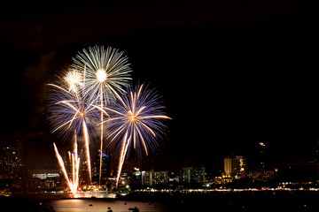 Fototapeta premium Many flashing fireworks with night cityscape background celebrate New Year.
