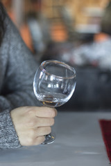 Vertical close-up shot for woman holds empty wine glass with blurry background in Izmir at Turkey for winter season