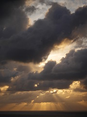 sunset sunshine rays coming out of the clouds down on the ocean