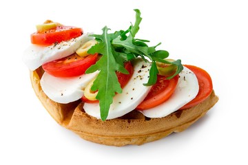 Belgium waffle with mozarella, tomatoes, olives and arugula isolated on white background