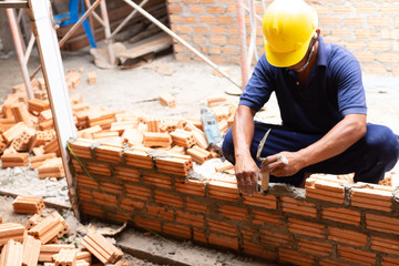 Close up of industrial bricklayer installing bricks on construction site