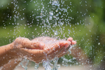 Water pouring in woman's hands. World Water Day concept.