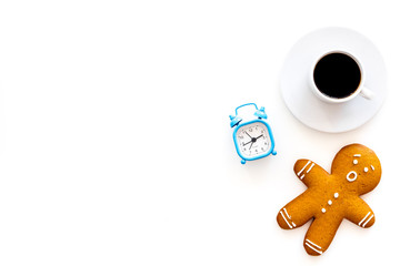 Time for coffee break. Coffee cup near gingerbread man, alarm clock on white background top view copy space