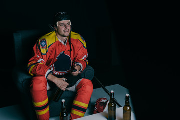 emotional hockey player drinking beer and watching tv on black