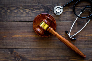 Medical law, health law concept. Gavel and stethoscope on dark wooden backgound top view copy space