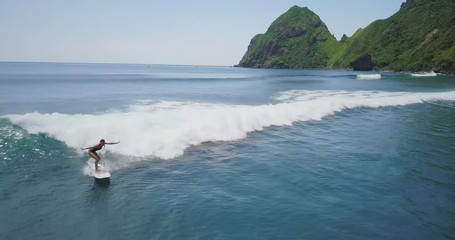 Camera follow fitness sexy surfer girl in blue sea or ocean. Young sporty lady ride her wave. Surfing school footage. Summer beach background. Sand and sea. Aerial drone slow motion footage Uhd 4K.