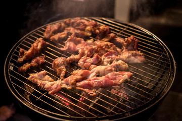 Barbecue or BBQ Grill with fresh meat cooking with smoke and fire hot on Thai street food dirty but yummy