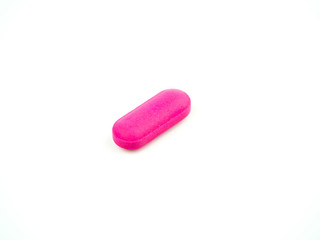 The pink pill is placed on a white background.