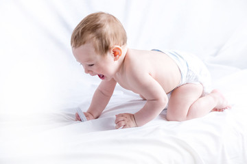 Cute blue-eyed baby 6-9 months playing on white background. Children's emotions. Cleanliness and care for babies