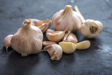 Group of garlic cloves scattered on a dark background. Important ingredient in different cuisines of the world