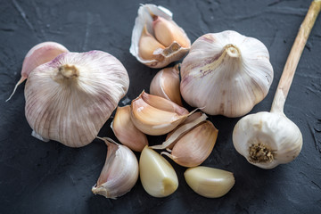 Group of garlic cloves scattered on a dark background. Important ingredient in different cuisines of the world