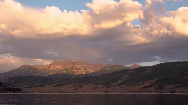 Relaxing view over Deer Creek Reservoir towards Timpanogos Mountain as the sun rises and lights up the landscape.