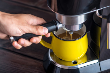 Preparation of espresso. Black coffee pouring from the machine into the Cup. Professional coffee brewing