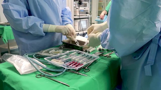 This is medicine related footage from hospital or clinic where professional doctors are operating a surgery or another type of medical healing procedure for injured patient.