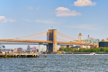 Suspended Brooklyn Bridge across the East River between the Lower Manhattan and Brooklyn.