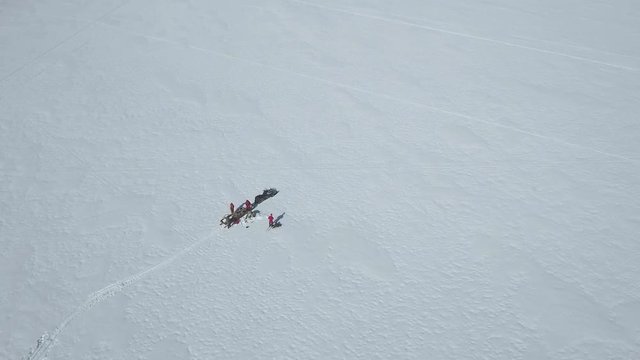 Finland's and Sweden's beautiful Tornio river at winter. Snowmobiles passing by and people ice fishing.
