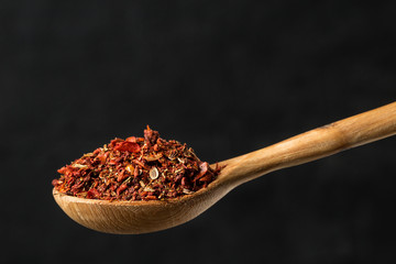 dried tomato powder in a wooden spoon close up