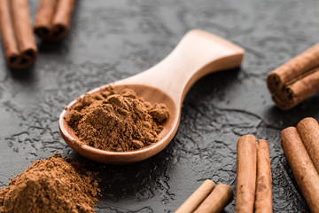 ground cinnamon spice powder in wooden spoon.