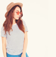 Portrait of young stylish laughing girl model in casual summer clothes in brown hat with natural makeup isolated on white background. In sunglasses.